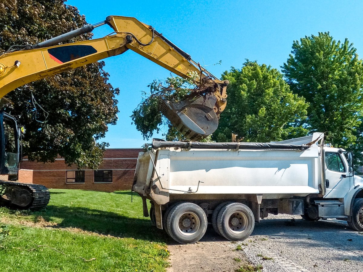 Heavy Construction Equipment loading excavated materials into a white dump truck
